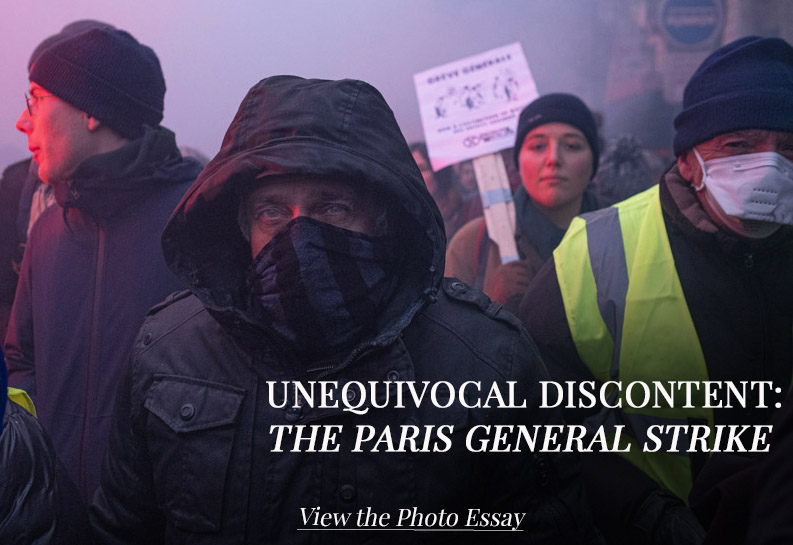 An old protestor looks directly at the camera during the protest in Paris